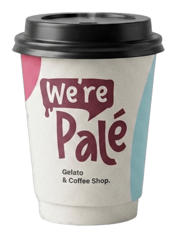 Un vaso de papel de café de Palé con tapa negra, impreso con “We're Palé — Gelato & Coffee Shop”